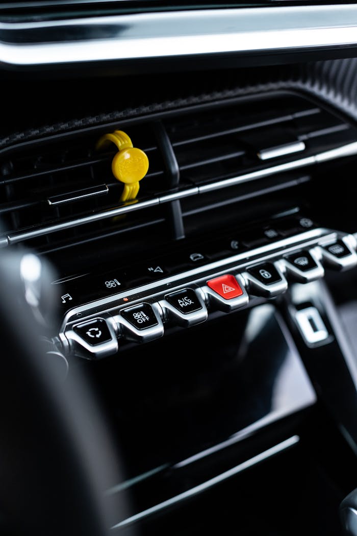 Services-03 Close-up view of a sleek car dashboard with controls and a vent clip.