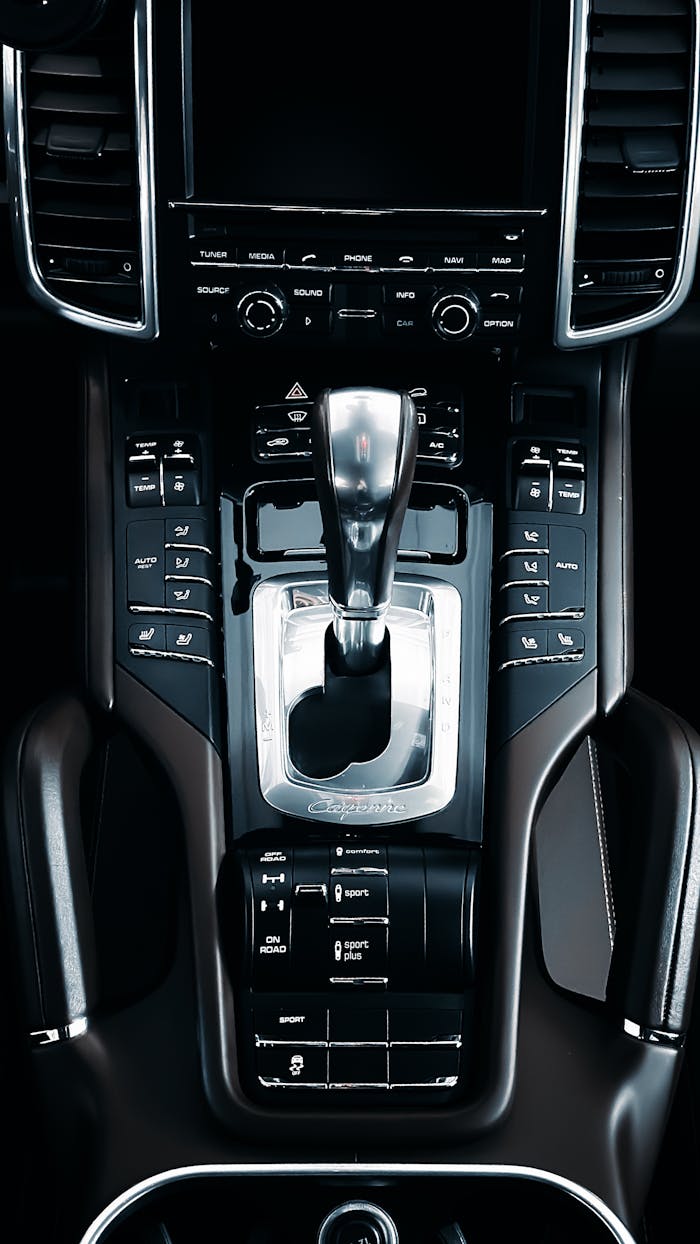 Services-01 Closeup view of a luxury car center console and gear shift, highlighting sleek design.